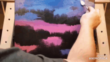 a person is painting a sunset on a canvas with a brush