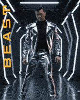a man in a silver jacket and pants is standing in a dark room with the word beast in orange