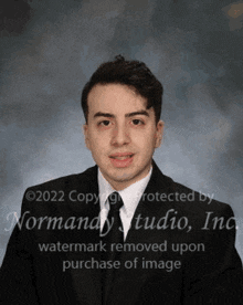 a young man in a suit and tie poses for a photo .