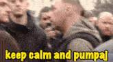 a man speaking into a microphone in a crowd with the words keep calm and pumpaj below him