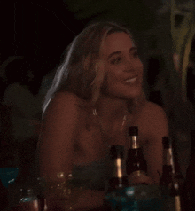 a woman sits at a table with bottles of beer including one that says citra on it