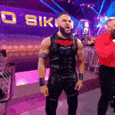 a wrestler is standing in front of a sign that says ' o siki '