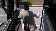 a man is getting out of a bus with the door open and his arms up
