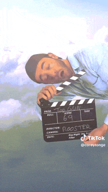 a man holding a clapper board that says rooster