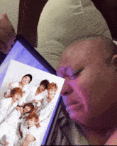 a man is crying while looking at a picture of a group of people