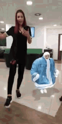 a woman is taking a picture of herself while standing next to a mannequin wearing a denim jacket .
