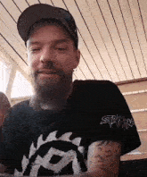 a man with a beard is wearing a shirt that says stamina on the sleeve