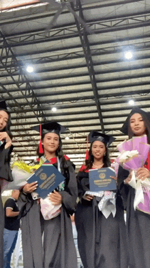 a group of female graduates are posing for a picture with their diplomas