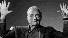 a black and white photo of a man with his hands in the air
