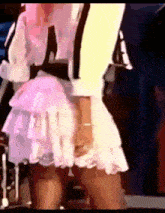 a woman in a pink and white dress is dancing on a stage