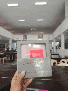 a person holding a class of 2025 card in their hand