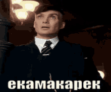 a man with a mustache is wearing a tuxedo and bow tie and has a foreign language on his face .