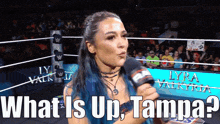 a woman with blue hair is holding a microphone and asking what is up tampa