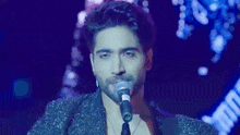 a man with a beard is singing into a microphone .