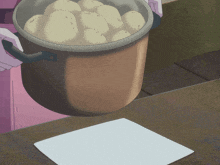 a person is holding a pot of potatoes over a piece of paper