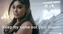 ariana grande is wearing angel wings and says `` keep my name out your mouth '' in a video .