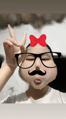 a girl wearing glasses and a fake mustache is giving a peace sign