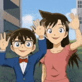 a boy and a girl are standing next to each other and waving at the camera .