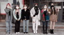 a group of women wearing face masks standing in front of a building that says newsinstar on it