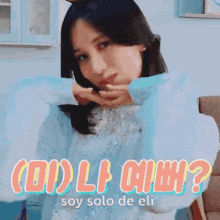 a woman is holding a cat in her arms and the words `` soy solo de eli '' are on the bottom of the image .