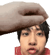 a hand is holding a man 's head in a pixelated image .