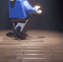 a lego figure is walking on a wooden floor and the word froggo is on the bottom right