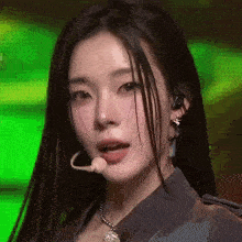 a close up of a woman 's face with a microphone around her neck