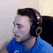 a man wearing headphones is sitting in front of a window