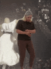 a woman in a black shirt is dancing in front of a crowd with a viggle.ai logo