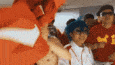 a group of people are dancing on a plane . one of the people is wearing a red shirt with the number 41 on it .