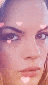 a close up of a woman 's face with pink hearts coming out of her eye