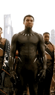 a group of men are standing next to each other and one of them is wearing a black suit .