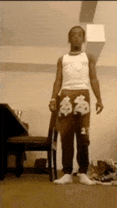 a man in a white tank top and black sweatpants with the number 27 on them