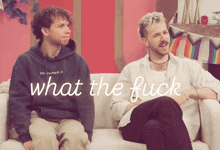 two men sitting on a couch with the words " what the fuck " on the bottom