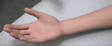 a close up of a person 's hand laying on a white surface
