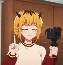 a girl with horns on her head is holding a canon camera