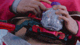 a person in a pink shirt is holding a toy that says ' slash ' on the front