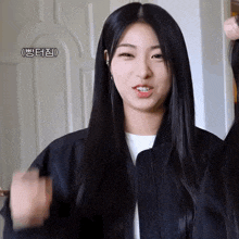 a girl with long black hair is wearing a black jacket and a white shirt