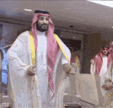 a man in a white robe with a red and white checkered head scarf