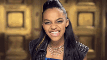 a young woman wearing a necklace and a leather vest is smiling