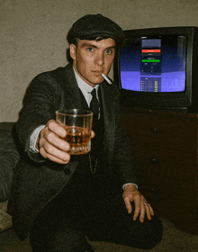 a man in a suit is holding a glass of whiskey