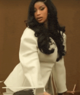 a woman with long black hair is wearing a white top