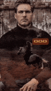 a man is sitting in front of a fence with a woman riding a horse .