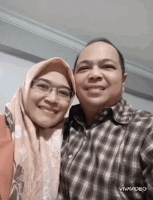 a man and a woman are posing for a picture together .