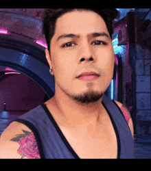 a man with a beard and a tattoo on his arm looks at the camera