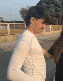 a man in a white shirt is standing next to a woman .