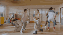 a group of people are dancing in a hallway and one of them has the letter fe on his shirt