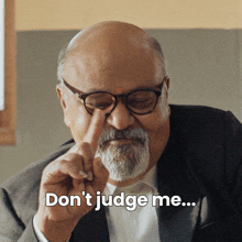 a bald man with glasses and a beard says " don 't judge me "