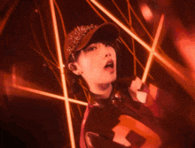 a woman wearing headphones and a hat with the letter t on her shirt