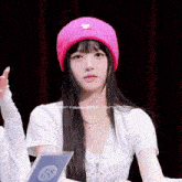 a girl wearing a pink beanie and a white shirt that says angel